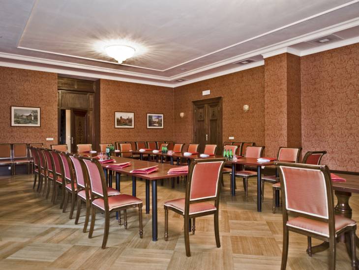 sala konferencyjna w kolorze brązowym, z brązowymi stołami i krzesłami